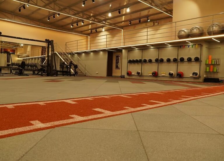 Functional training zone with red turf track and equipment wall